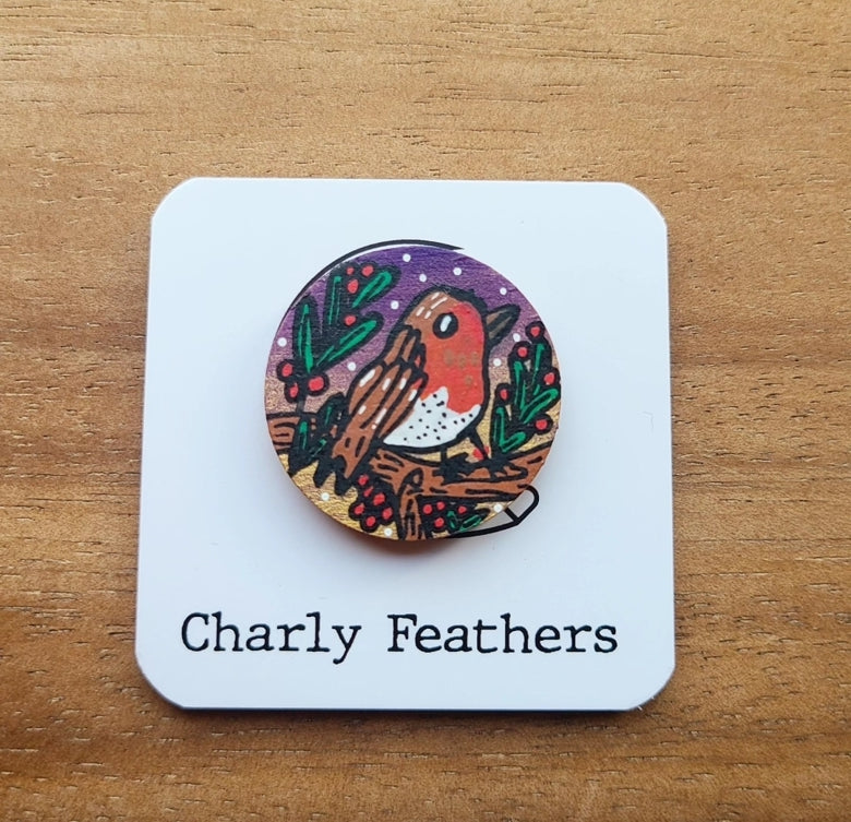 Wooden needle minder with a robin design on a white card labeled 'Charly Feathers' against a wooden background