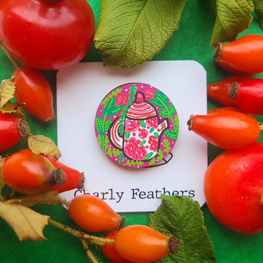 Colorful needle minder on a card with red fruits and green leaves in the background