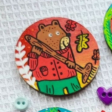 illustration of bear sweeping leaves on needle minder