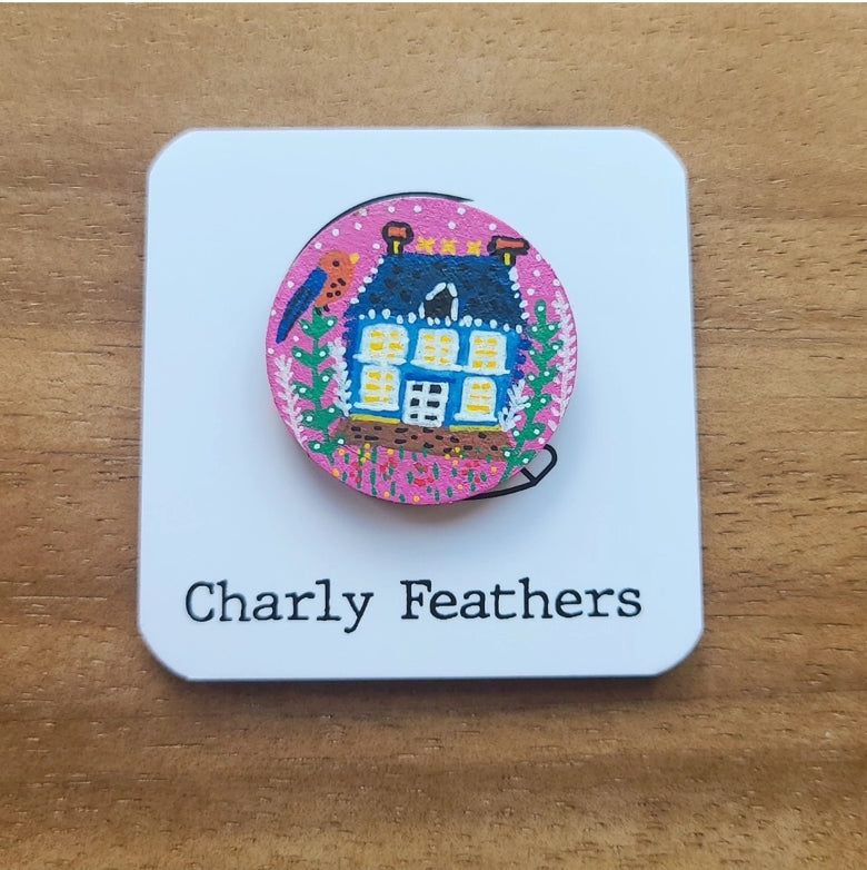 illustration of blue house on pink needle minder