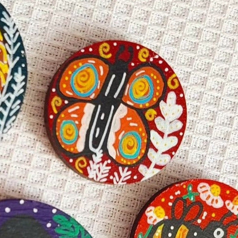 illustration of orange butterfly on red needle minder