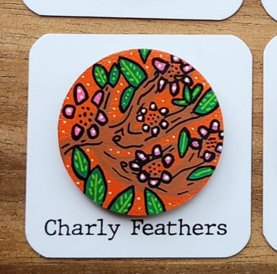 cherry tree design needle minder on a white card labeled 'Charly Feathers' against a wooden background.