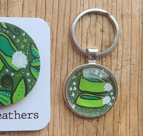 Keychain with green design on a wooden surface