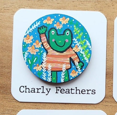 Colorful needle minder with a cartoon frog on a white card labeled 'Charly Feathers'.