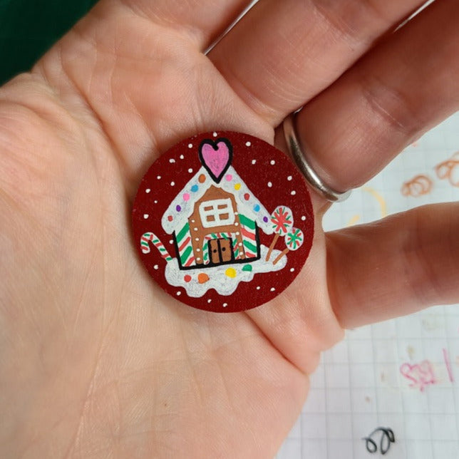 illustration of ginger bread house on red needle minder