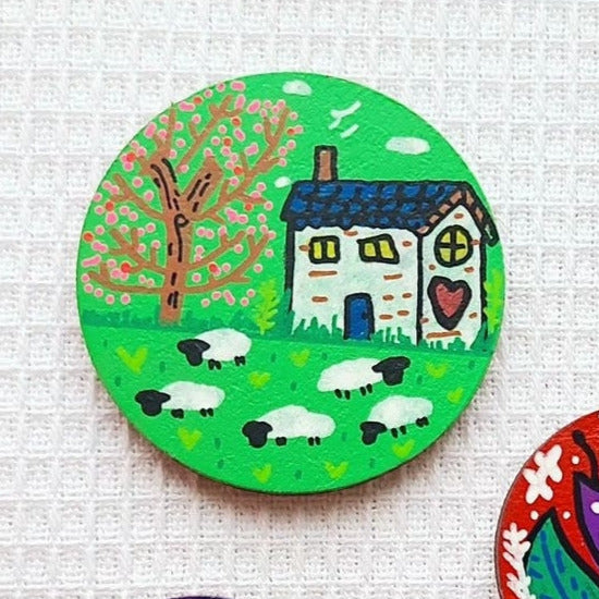 illustration of white cottage on green needle minder