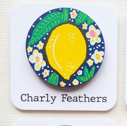 colorful needle minder with lemon illustration and 'Charly Feathers' branding on a white background.