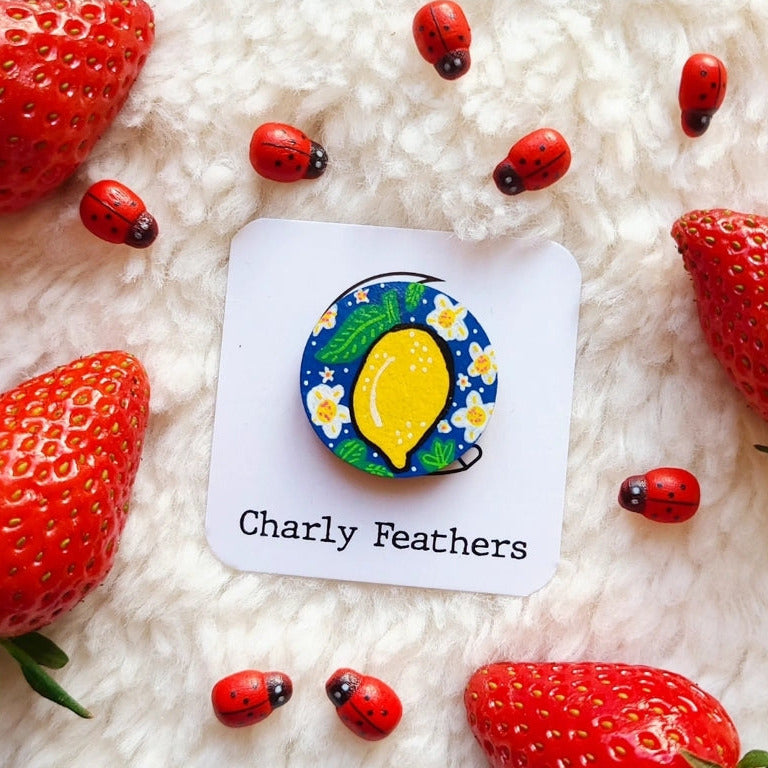 needle minder with lemon design on a card labeled 'Charly Feathers' surrounded by strawberries and ladybugs.