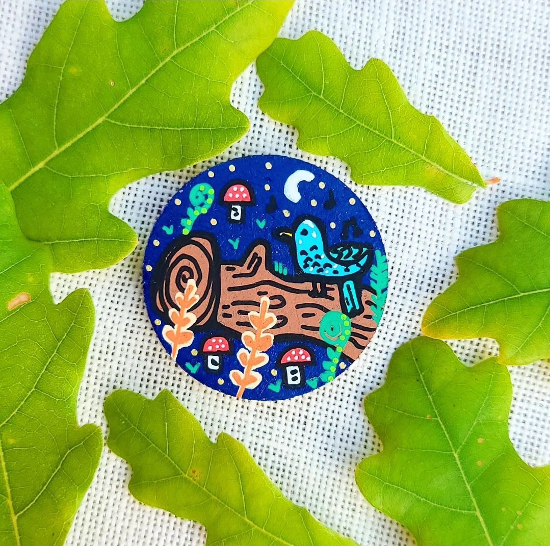 hand painted illustration of bird on a branch with mushrooms and ferns on needle minder