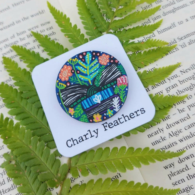 illustration of books open with colourful plants on large needle minder