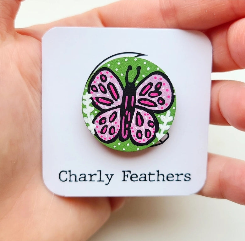 illustration of pink butterfly on green needle minder