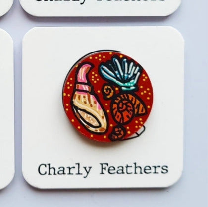 illustration of shells on small needle minder by Charly Feathers on white cards with a light gray background.