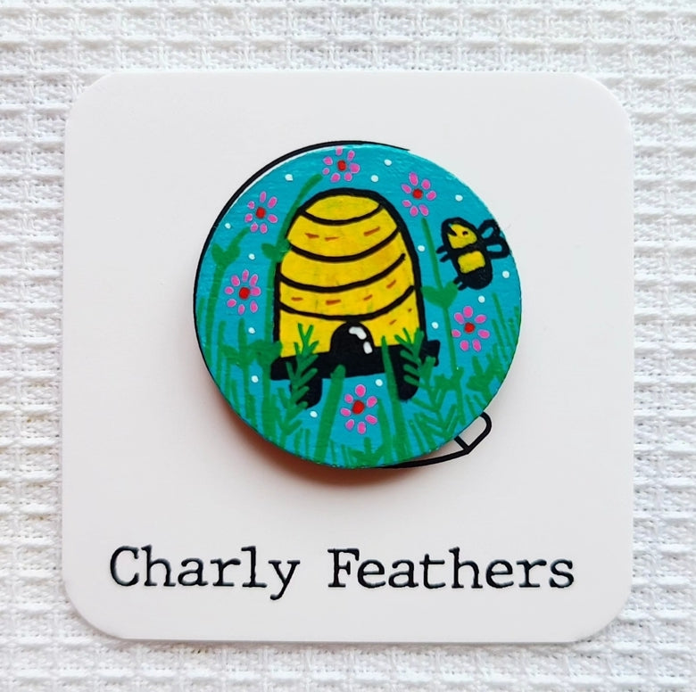 small needle minder with bee and beehive design on a white card with 'Charly Feathers' branding.