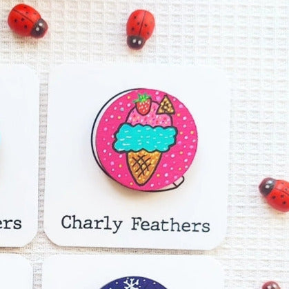 Colorful ice cream needle minder with ladybug accents on a white background, featuring the brand 'Charly Feathers'.