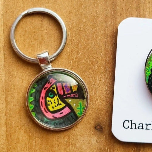 Keychain with colorful toucan design on a wooden surface