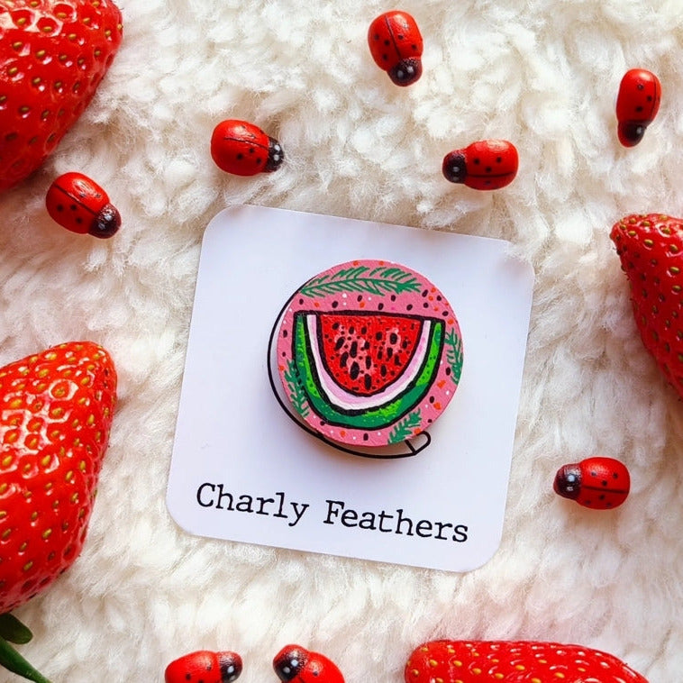 Watermelon-themed needle minder with 'Charly Feathers' branding on a white card, surrounded by strawberries and ladybugs.