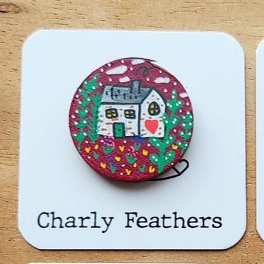 white cottage illustration on small needle minder
